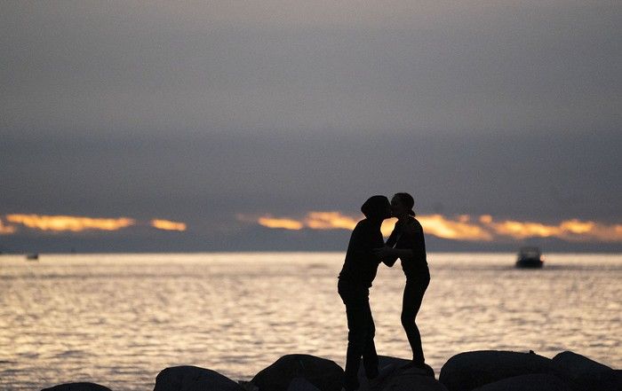 A couple kisses while walking on a rock jetty at Sunset Beach in Vancouver. A couple kisses while walking on a rock jetty at Sunset Beach in Vancouver.