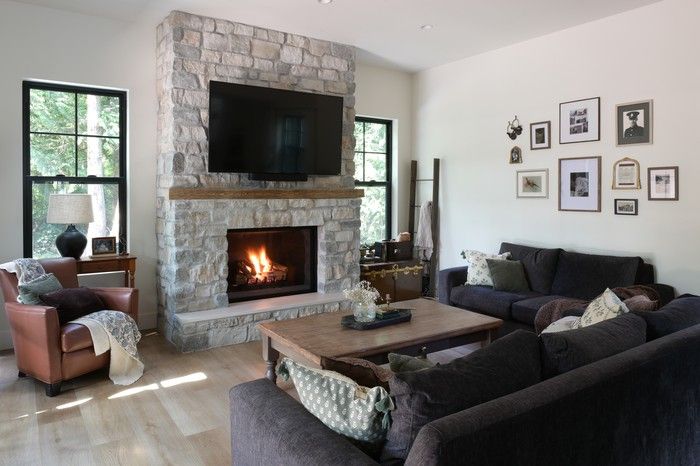  A fireplace – clad in Mountain Ridge fieldstone – adds a touch of cottage-style coziness to a living room filled with an eclectic mix of modern and vintage furnishings.