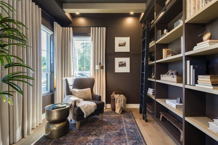  A cosy den on the main floor. Walls and ceiling painted in a peppery hue add moody drama.