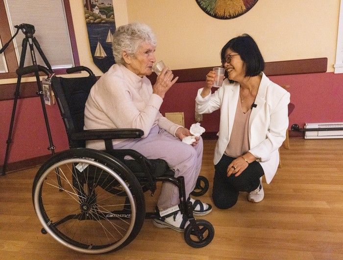  lillian hung, clinical nurse specialist vch, with barbara mchale as seniors watch tv at rosewood manor.