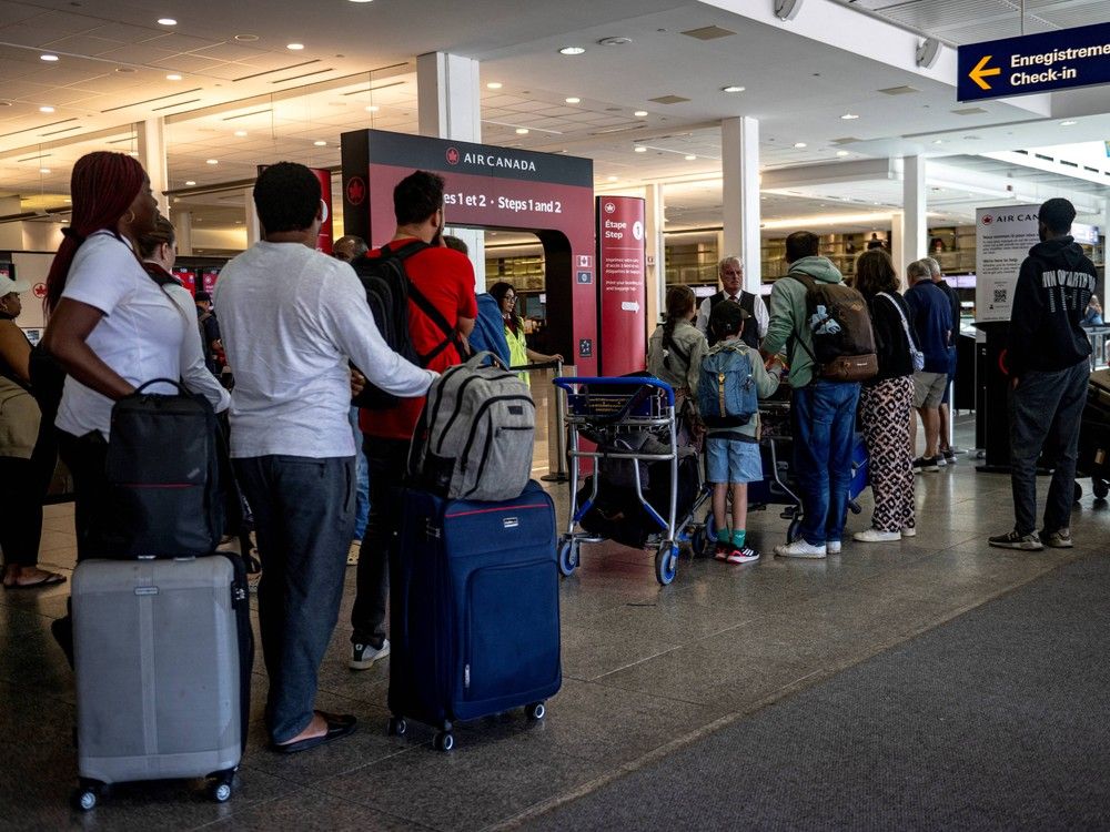  Passengers queue to check-in at Pierre-Elliott Trudeau Airport in Montreal, Que. on Aug. 19, 2025 as Air Canada flights were slated resume.