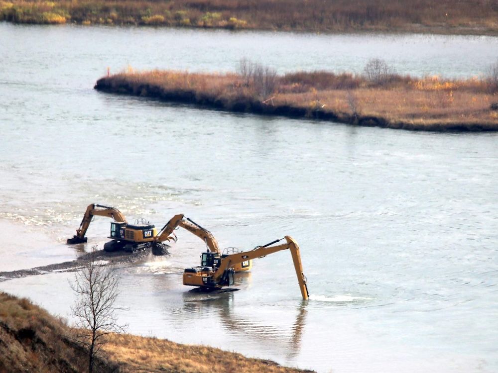  Excavators do digging work on the Peace River, as part of the Site C dam construction project in 2015.
