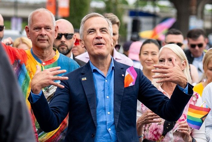 Prime Minister Mark Carney fans himself while he marches in the Vancouver Pride Parade in Vancouver, on Sunday, Aug. 3, 2025. Prime Minister Mark Carney fans himself while he marches in the Vancouver Pride Parade in Vancouver, on Sunday, Aug. 3, 2025.