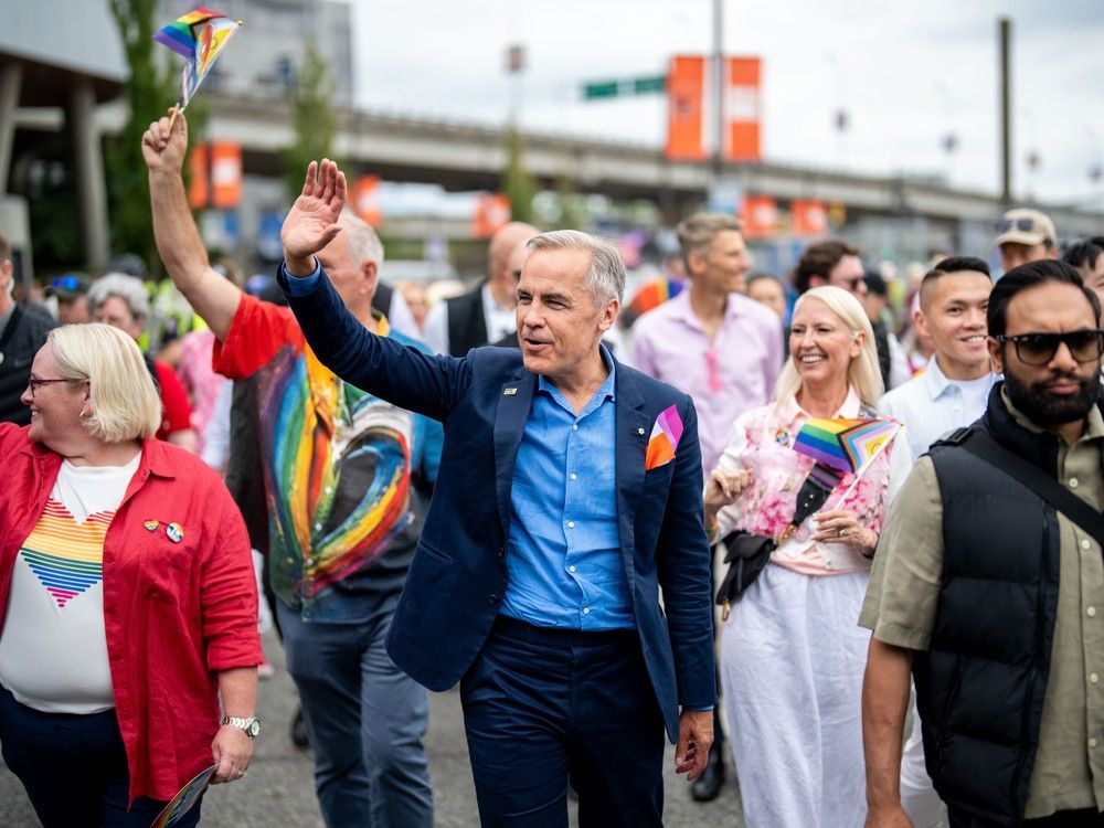 Prime Minister Mark Carney waves while he marches in the Vancouver Pride Parade in Vancouver, on Sunday, Aug. 3, 2025. Prime Minister Mark Carney waves while he marches in the Vancouver Pride Parade in Vancouver, on Sunday, Aug. 3, 2025.