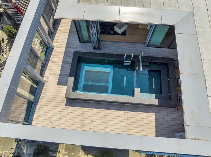  The penthouse’s 1,396-sq.- ft outdoor terrace encircles the hot tub and glass-bottomed pool, as well as indoor entertaining or games space.