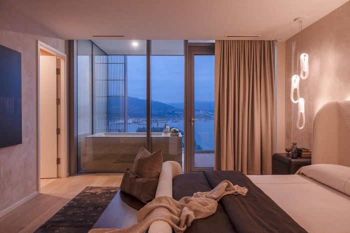  The primary bedroom with spa-inspired ensuite is accented by soft suede wallpaper and features an outdoor terrace with a second bathtub.