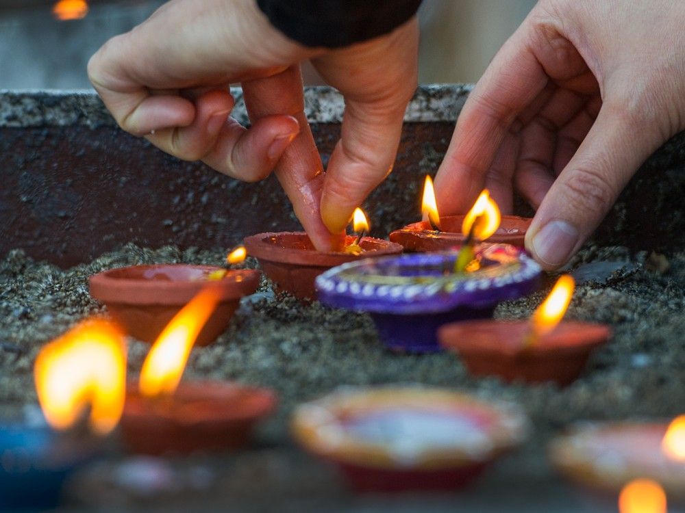 People lighting candles during Diwali in Surrey. People lighting candles during Diwali in Surrey.