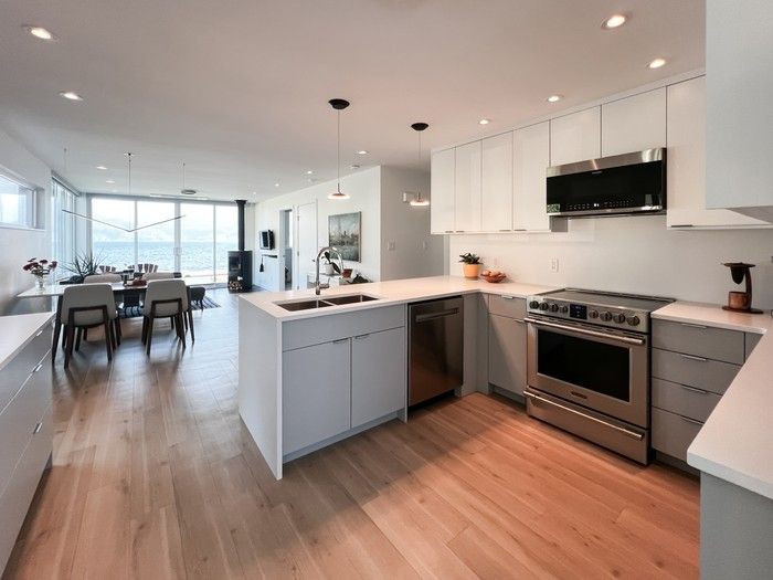 Millwork keeps the focus on views of Kootenay Lake and the Selkirk Mountains. A subtle pendant fixture, the Z-Bar Bird by Koncept , over the dining area casts light with minimal obstruction of sightlines.  Millwork keeps the focus on views of Kootenay Lake and the Selkirk Mountains. A subtle pendant fixture, the Z-Bar Bird by Koncept , over the dining area casts light with minimal obstruction of sightlines.