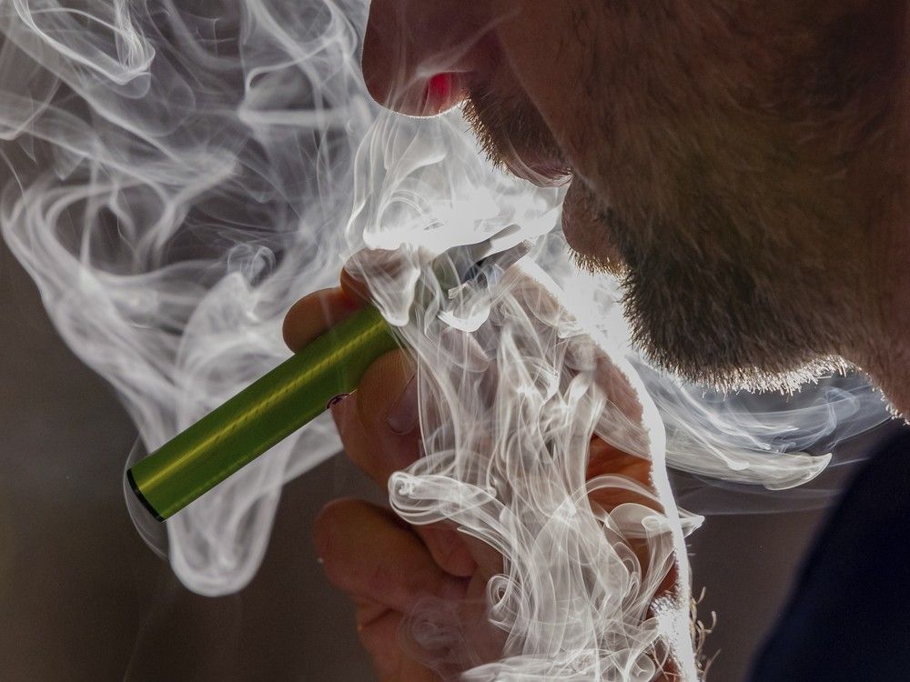 A man vapes on a disposable electronic cigarette. A man vapes on a disposable electronic cigarette.
