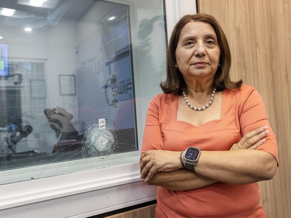 Jinny Sims, talk show host and former MLA, stands next to bullet holes after shots were fired at 1200 AM radio station in Surrey. Jinny Sims, talk show host and former MLA, stands next to bullet holes after shots were fired at 1200 AM radio station in Surrey.
