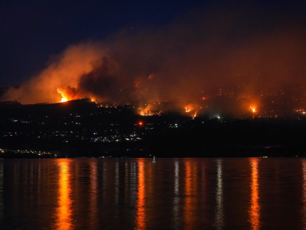 The McDougall Creek wildfire burns on the mountainside above lakefront homes in West Kelowna on Aug. 18, 2023.