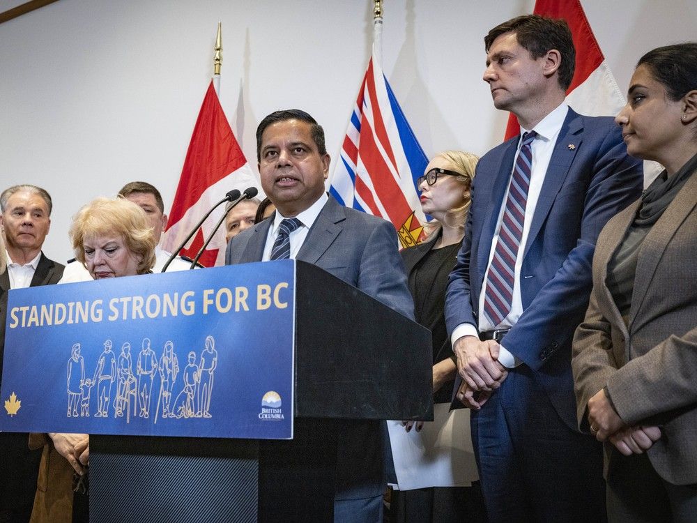  Police and politicians from local, provincial and federal levels, including federal Minister of Public Safety Gary Anandasangaree (centre) and premier David Eby, address the media at a round-table discussion in Surrey, BC Friday, November 28, 2025 formed to work on solutions to the rise of extortions plaguing the South Asian community in B.C.