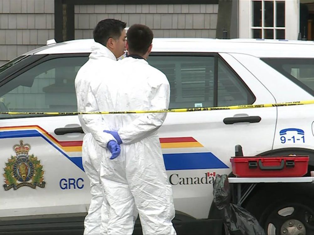 Officers in white forensic suits are seen outside a one-storey office building on Hope Place in Chemainus on Friday. 