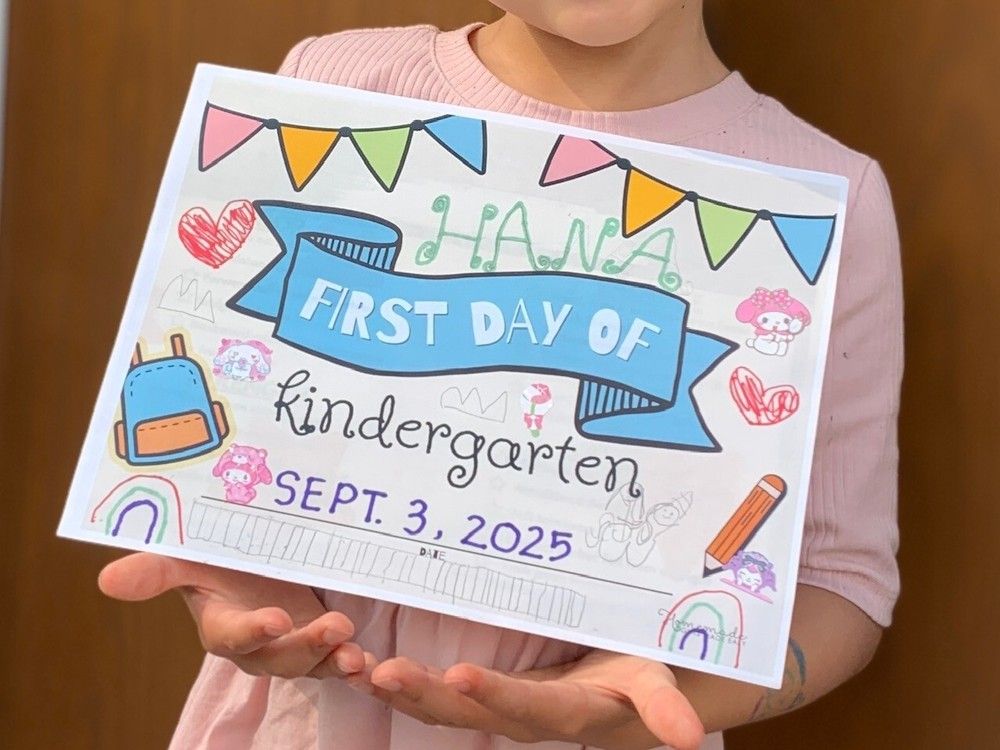  a child holds up a first day of kindergarten sign in vancouver.