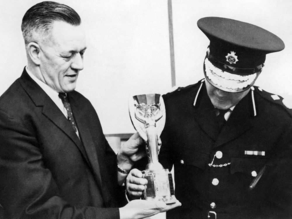  The Jules Rimet Cup found by a dog named “Pickles”, 28 March 1966 in a garden in suburban London, is shown to journalists by two Scotland Yard police officers.