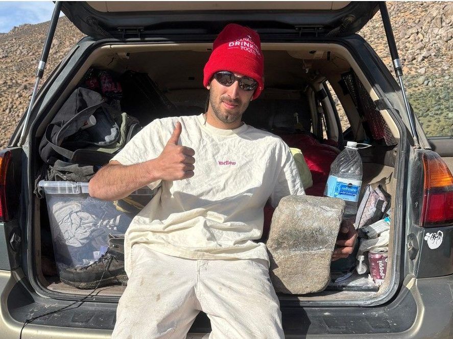 Ethan Salvo poses with the mini boulder 'Portable' in his car in Bishop, Calif. The rock is a well-known part of the Squamish climbing scene and went missing in September 2025.