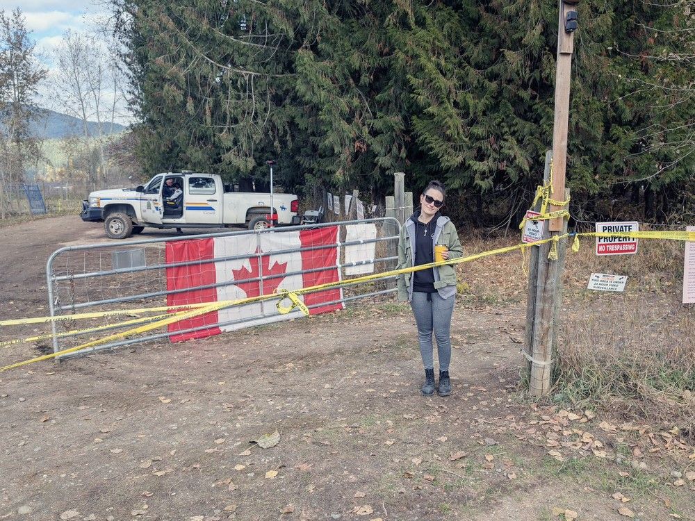 Allyson Turnbull in fall 2025 at her parents property — then festooned with police tape and with a nearby Mountie. The property is adjacent to the ostrich farm where birds were shot dead on government orders. Turnbull and her parents are suing the Canadian Food Inspection Agency and the RCMP for using their property without permission for the killing operation and allegedly treating them like prisoners.