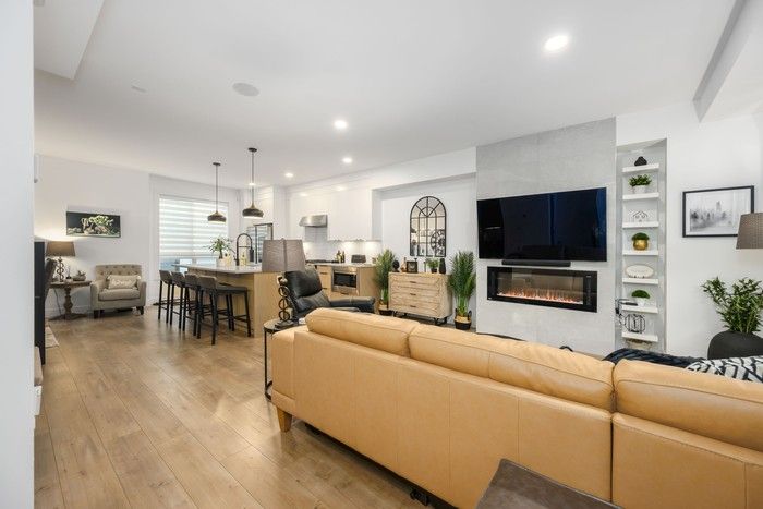  This three-bedroom townhouse features 10-foot-high ceilings, wide-plank floors, expansive windows, and a floating linear electric fireplace in the living room.