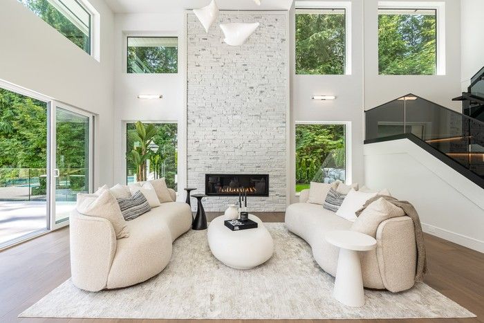  Grand living area with soaring ceilings, clerestory windows, and a dramatic stone fireplace.