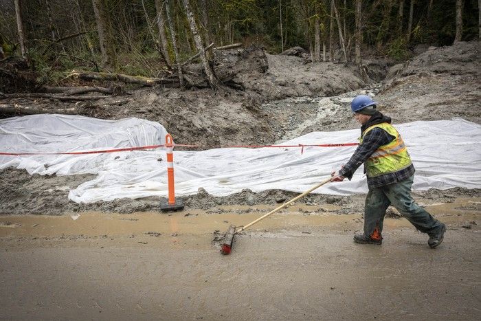  A worker removes debris from Pipeline Road in Coquitlam.