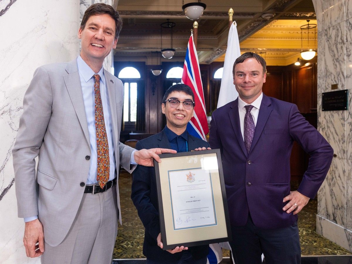 Premier David Eby (left) and B.C. Indigenous Relations Minister Spencer Chandra Herbert flank Kitselas First Nation Councillor Cyril Bennett-Nabess at an event marking the introduction of treaty enabling legislation on Wednesday, April 15, 2026, at the legislature in Victoria.
