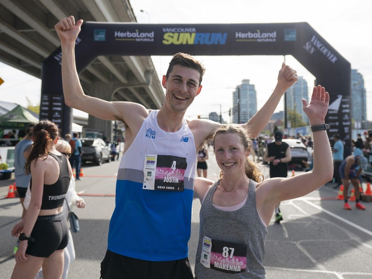 Makenna Fitzgerald, the first woman to cross the finish line at the Vancouver Sun Run, poses for photos with overall winner Justin Kent at the finish line.