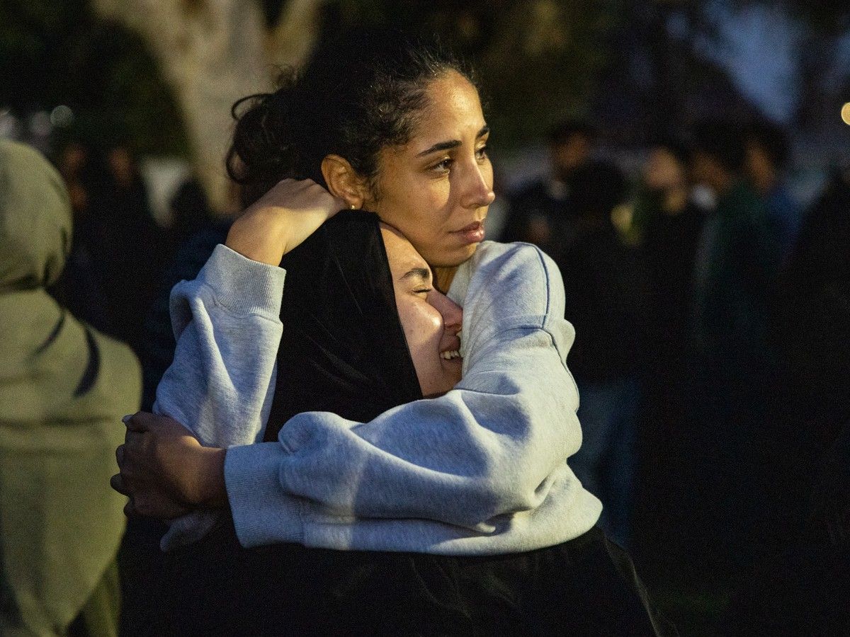 Community members embrace following a vigil for victims and families of a shooting at the Islamic Center of San Diego in San Diego, California, on May 19, 2026, a day after the attack. AFP.