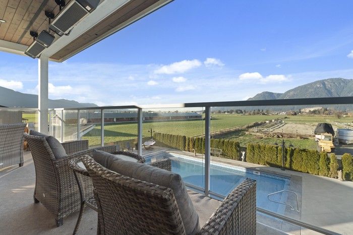  Property includes an in-ground pool with detached pool house/bar with sink and fridge, outdoor shower, in-ground hot tub, putting green, and expansive upper and lower heated decks with mountain views.