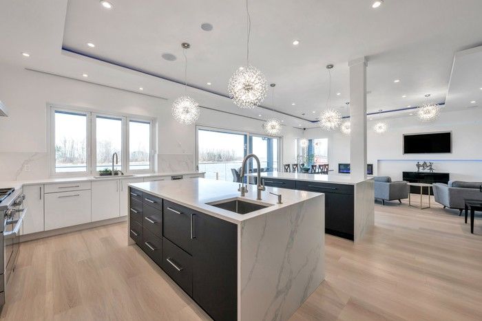 Kitchen features waterfall countertops, contemporary pendant lighting, a spice kitchen and premium Miele appliances.