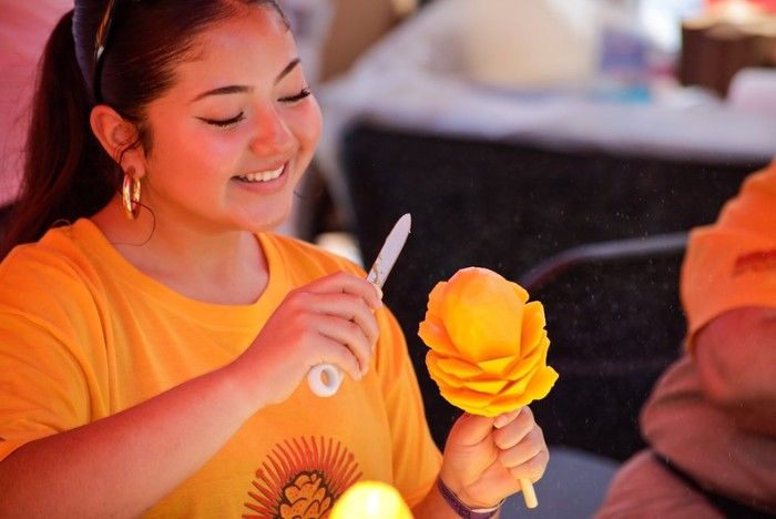 A Chilango Mango artist puts the finishing touches on a mango-on-a-stick treat. Credit: Courtesy of Latincouver