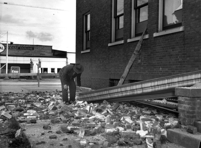 A resident of Courtenay, B.C. inspects earthquake damage to the Courtenay post office. The earthquake occured June 23, 1946. 
