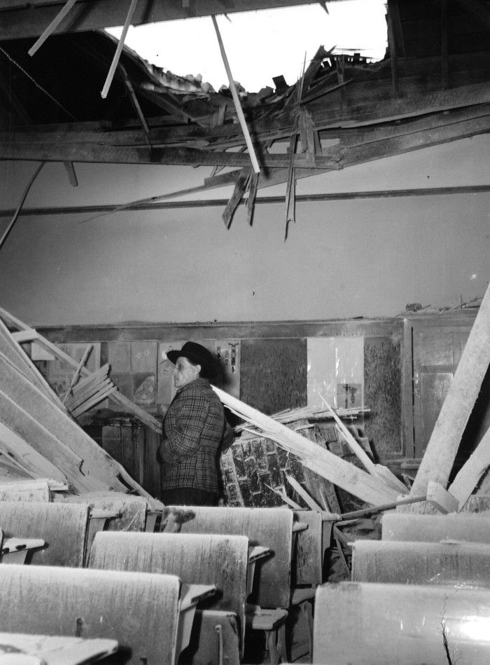  A resident of Courtenay inspects earthquake damage to a school room in the city. The earthquake occurred June 23, 1946. Vancouver Public Library