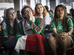 Mexican soccer fans (from left foreground) Dilara Karaca, Rodrigo Zertuche and Nadia Sanchez watch the opening match of the FIFA World Cup 2026 at The Cambie in Vancouver on June 11, 2026. Fans could watch the opening match from several areas Thursday, including the FIFA Pedestrian Zone on Granville Street in downtown Vancouver.