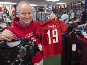 Ferruccio Susin, owner of North American Sports in Vancouver, holds team Canada soccer jerseys at his store Friday.
