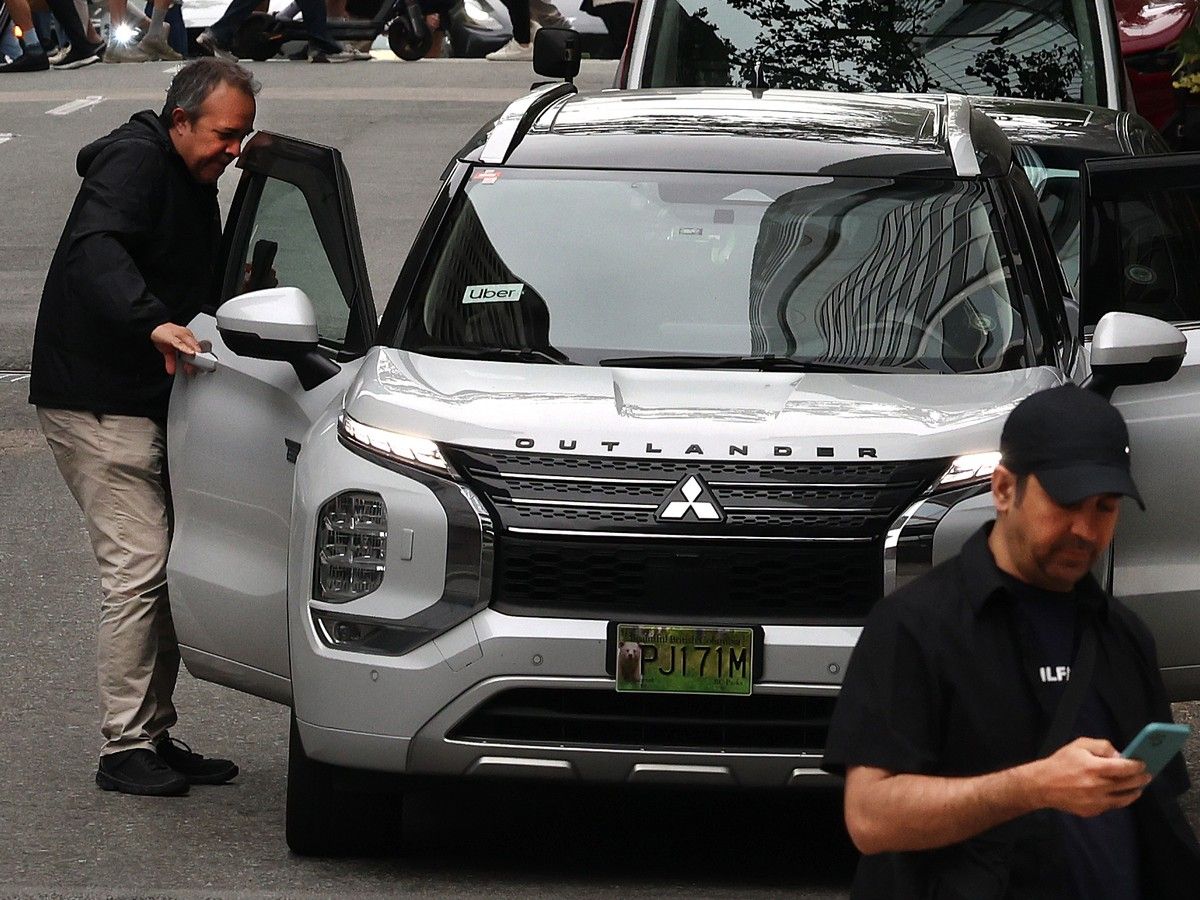 A ride-hailing driver picks up a passenger near Waterfront Station.