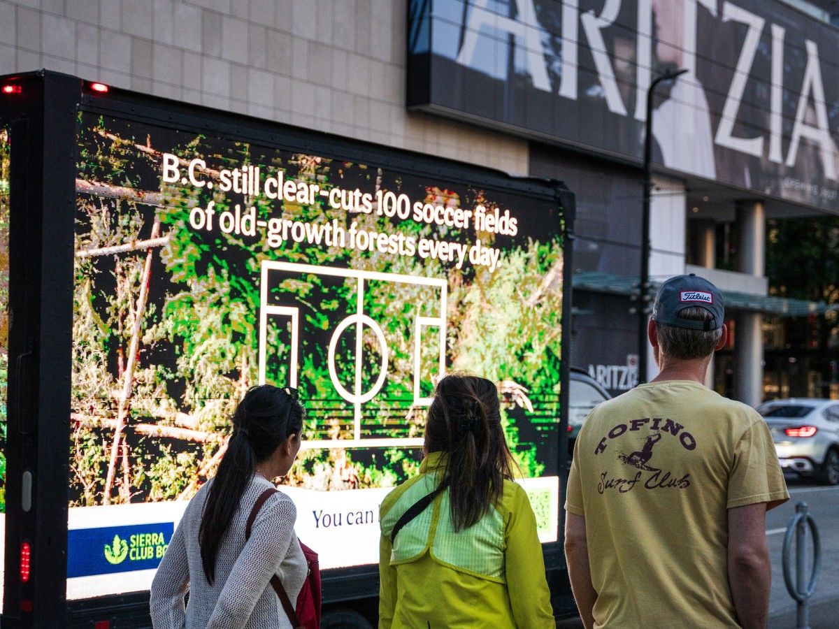 Visitors look at an advertisement launched by Sierra Club