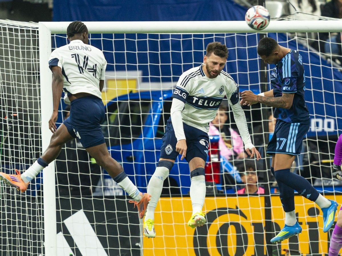 Diego Borges of Sporting Kansas City clears the ball away from Bruno Caicedo and Tristan Blackmon of the Vancouver Whitecaps at B.C. Place on April 17.