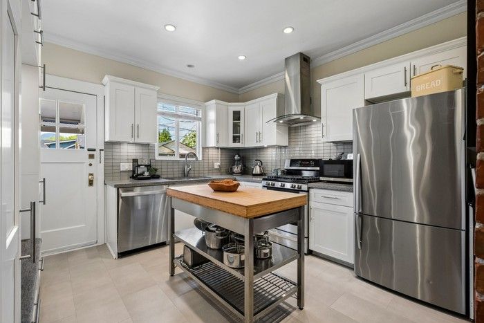 Kitchen features Shaker-style cabinets and stainless-steel appliances.