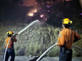 A pair of B.C. Wildfire Service firefighters tackle the Bald Range fire on the night of Aug 7/8, 2026.