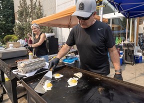 Volunteers Chris and Cathy Terris cook outside Penticton Trade and Convention Centre