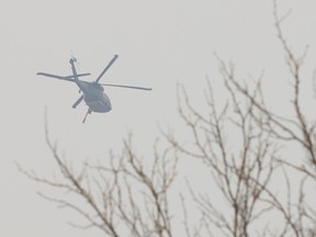 A firefighting helicopter passes over Penticton Trade and Convention Centre on August 11, 2026.