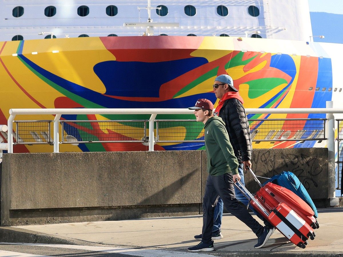 People walk with their suitcases outside the Canada Place cruise ship terminal on Monday, Oct. 12, 2026, as the season ends with a record number of passengers.