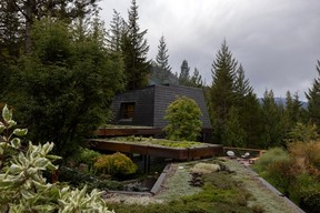 Black slate shakes give the exterior the feel of a rock formation, while angled upper walls keep views from the main house open. Copper downpipes and fascia will darken over time as they weather.