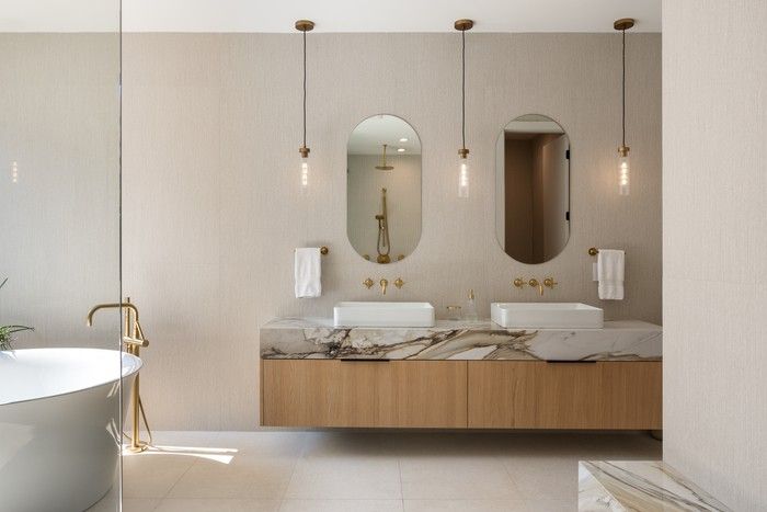 Primary en suite features a walk-in shower with stone bench and brass fittings, black-framed glass doors and freestanding tub.
