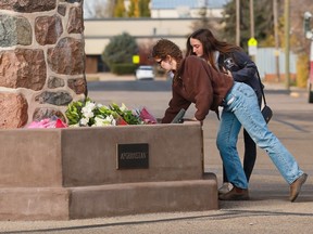Wainwright residents place flowers at the cenotaph in Wainwright, Alberta on Monday, Oct. 19, 2026.