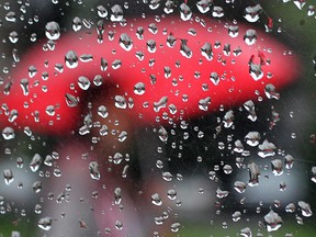 In this file photo, a pedestrian is reflected in a mirror in Windsor, Ont  during a rainy day September Monday. AccuWeather.com senior meterologist Brett Anderson says on Wednesday, Aug. 21, 2013, that the second half of September through a good chunk of October does look wetter than normal in Southwestern Ontario. (DAN JANISSE/THE WINDSOR STAR)
