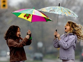 Cousins Valentina DiPietro, 8, left, and Zelia Piasentin, 8,  are all smiles as they make their way down Curry Avenue in south Windsor during  a steady rainfall on April 25, 2011 in Windsor, Ont.  (Jason Kryk/The Windsor Star)
