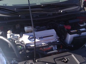 The "engine" bay of a Nissan Leaf; inverter atop motor, 12 v accessory battery on far right.