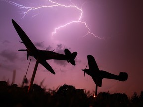 Lightning bursts across the sky as the Spitfire and Hurricane planes are silhouetted at Jackson Park in Windsor, Ont. during summer storms. (JASON KRYK/ The Windsor Star)