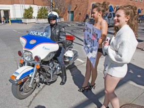 In this file photo, Emily Lavender (L) and Stephanie Laoun (R) draw the attention of an Ottawa Police Officer during a 2010 protest. (Wayne Cuddington/Ottawa Citizen)